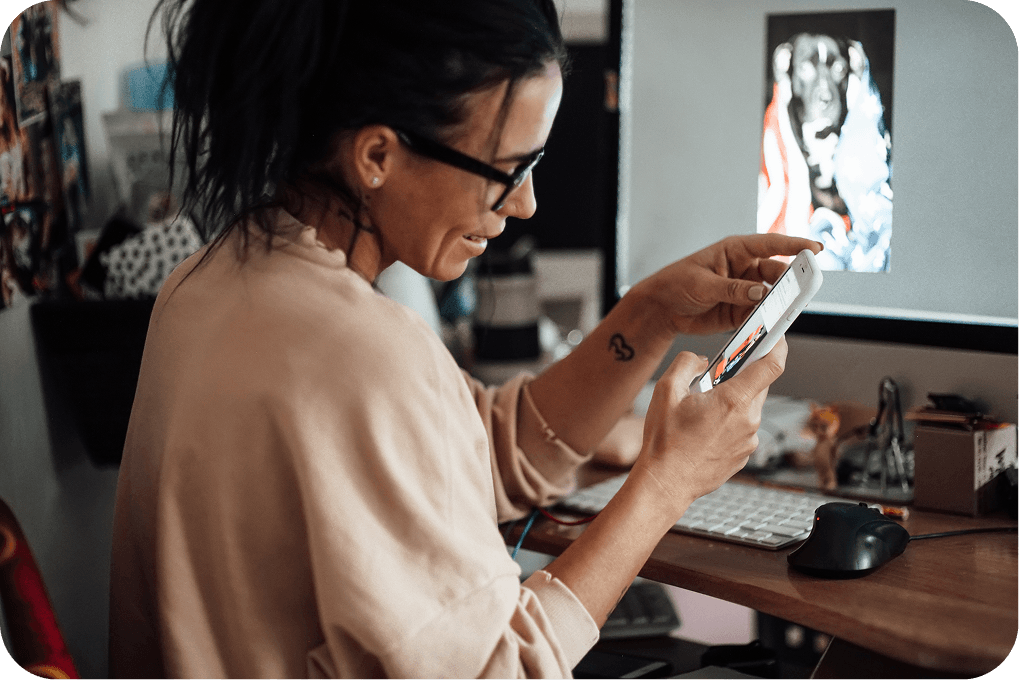 Person at a desk with their phone