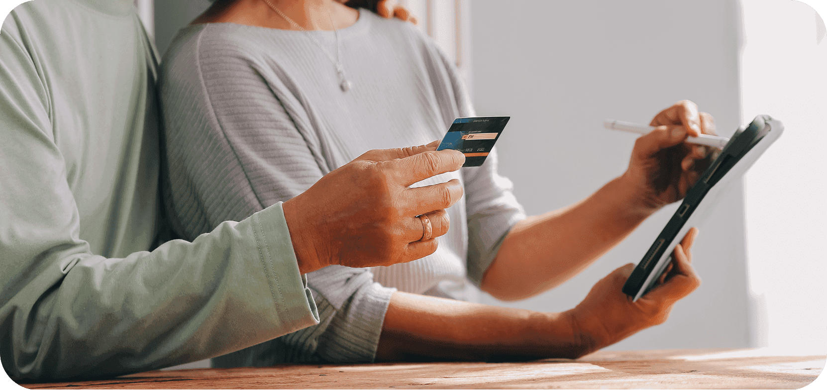 Hand holding a payment card next to a phone